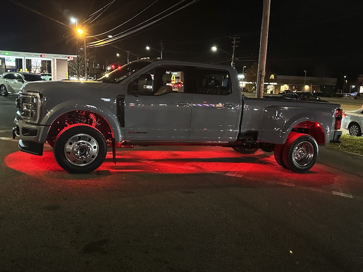Truck with custom red underglow lighting at night