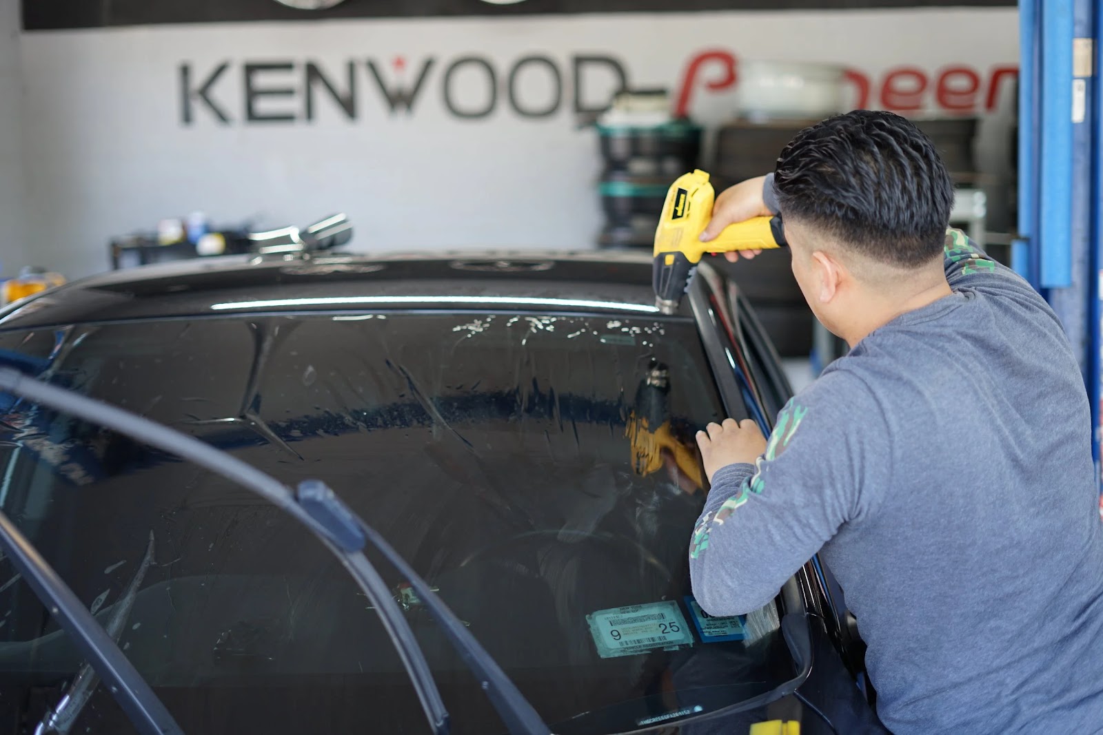 Technician applying window tint film to a vehicle
